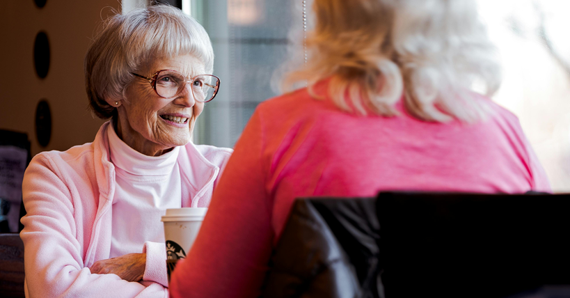Dos mujeres hablando en una cafetería.